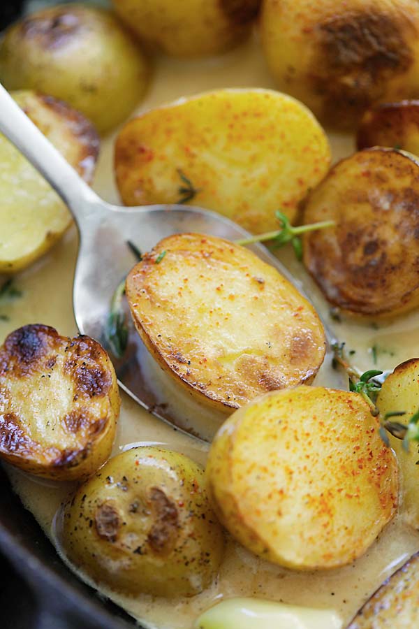 Close up white creamy garlic thyme golden potatoes.
