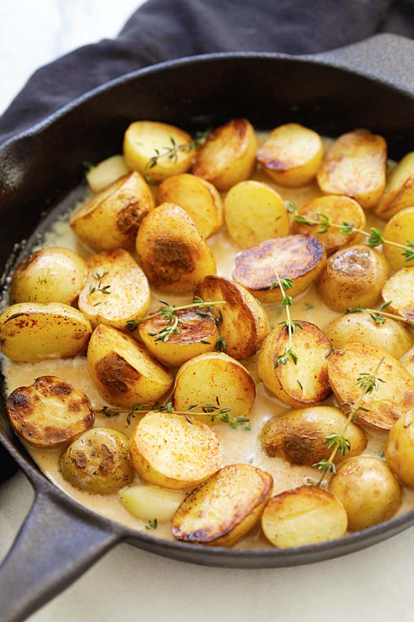 Easy and quick creamy potatoes with garlic thyme in buttery and homemade creamy sauce in a skillet.