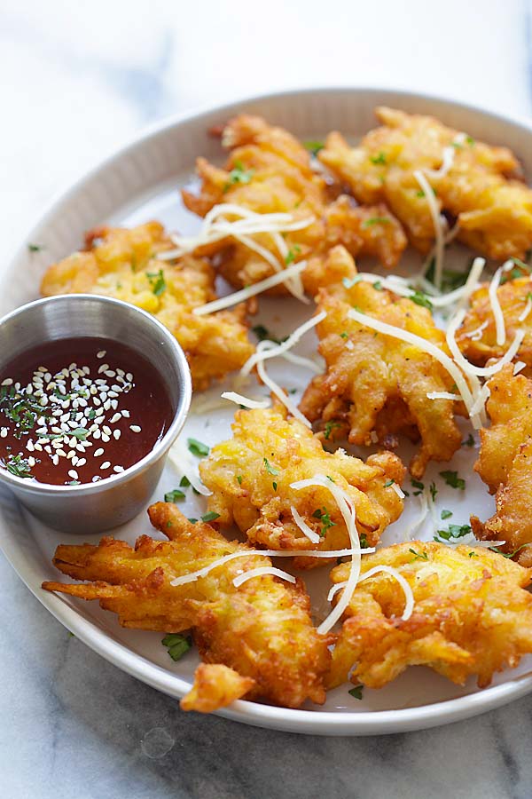Homemade pumpkin fritters recipe with Parmesan cheese in a plate with a side dipping sauce.