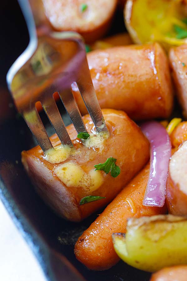 Skillet cheesy sausage and potatoes with a fork ready to serve.