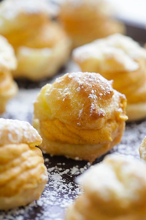 Easy homemade pumpkin cream puffs dusted with powdered sugar.