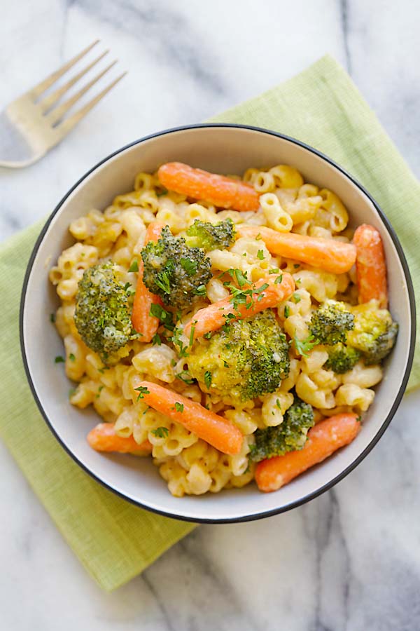 Creamy and cheesy mac and cheese with broccoli and carrots in a plate.