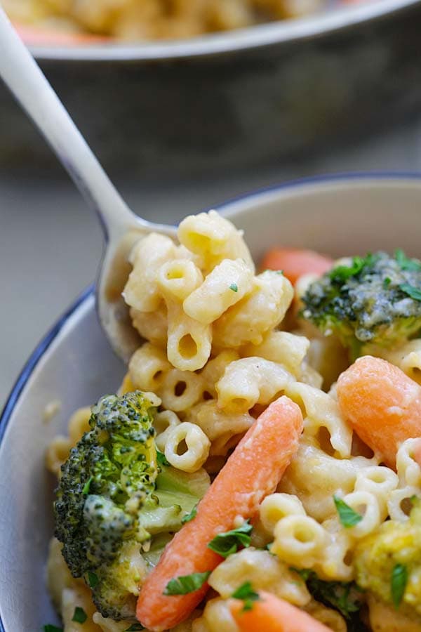 Easy and quick mac and cheese with broccoli and carrots with a spoon.