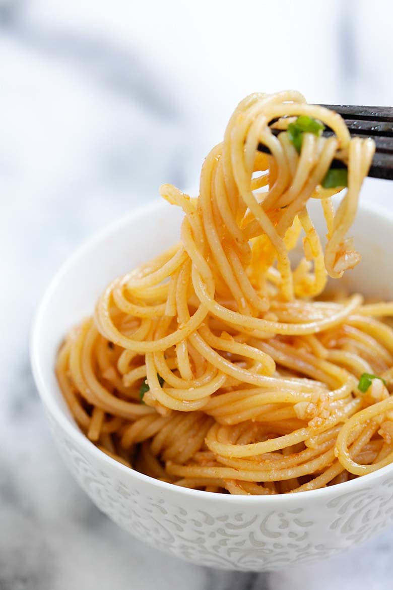 Easy and healthy garlic noodles with Sriracha, picked by a fork.