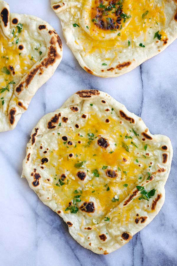 Indian style homemade naan topped with garlic and cheddar cheese.