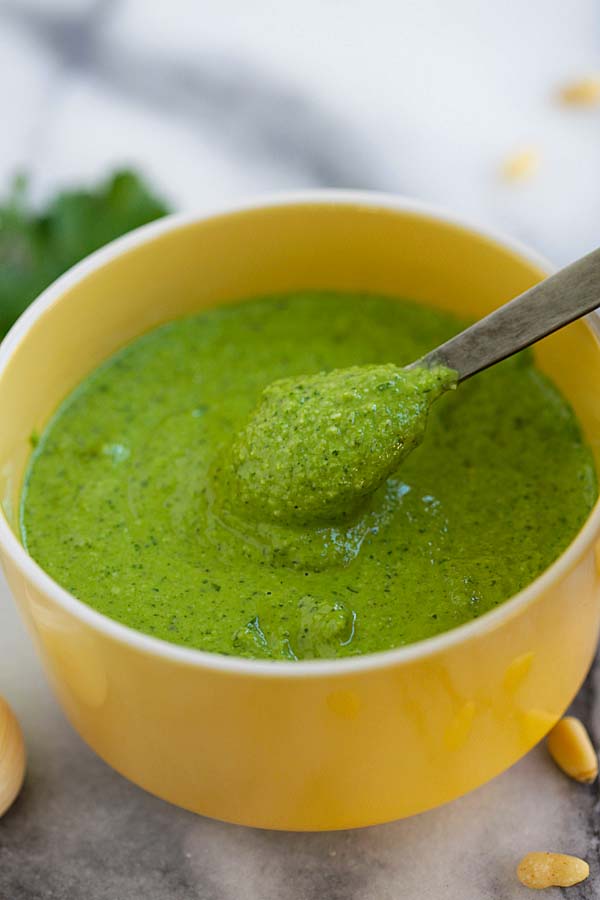 Easy homemade Italian pesto sauce served in a bowl and a sauce spoon.