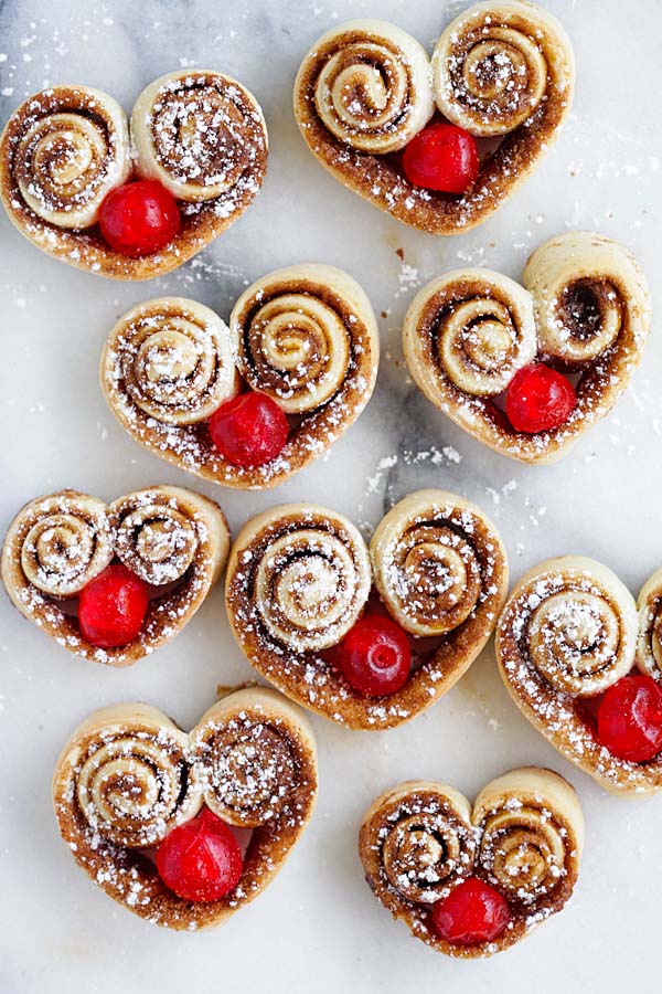 Easy and delicious baked heart shaped cinnamon rolls stuffed with red cherries.