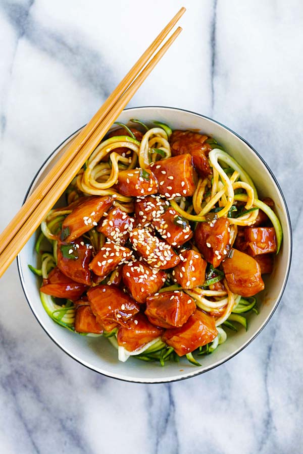 Top down view of easy and quick stir fry honey sriracha chicken on top of zucchini noodles in a bowl.