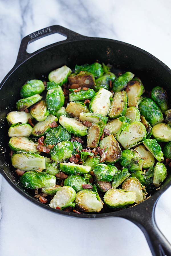 Easy and healthy homemade skillet roasted Brussels sprouts with garlic, Parmesan cheese and bacon.