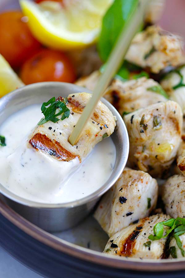 Mediterranean chicken bites in a skewer, dipped into ranch dressing sauce.