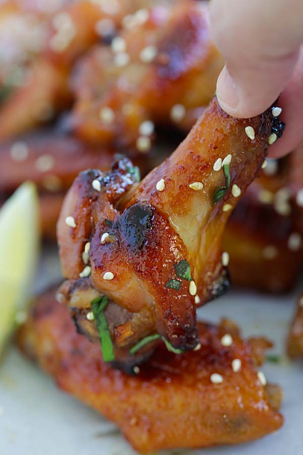 Homemade honey miso Japanese-flavored chicken wings picked with fingers.