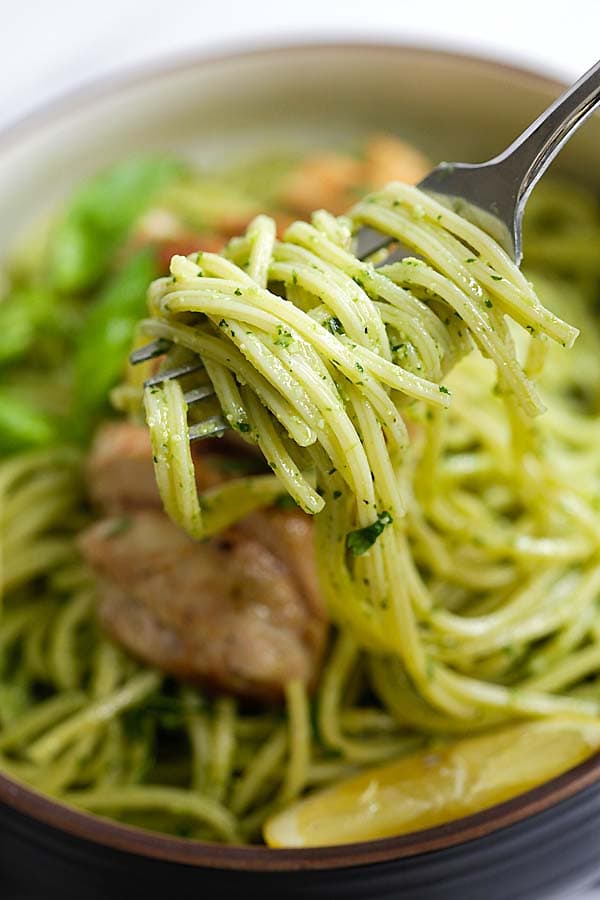 Pesto spaghetti pasta twirled on a fork.