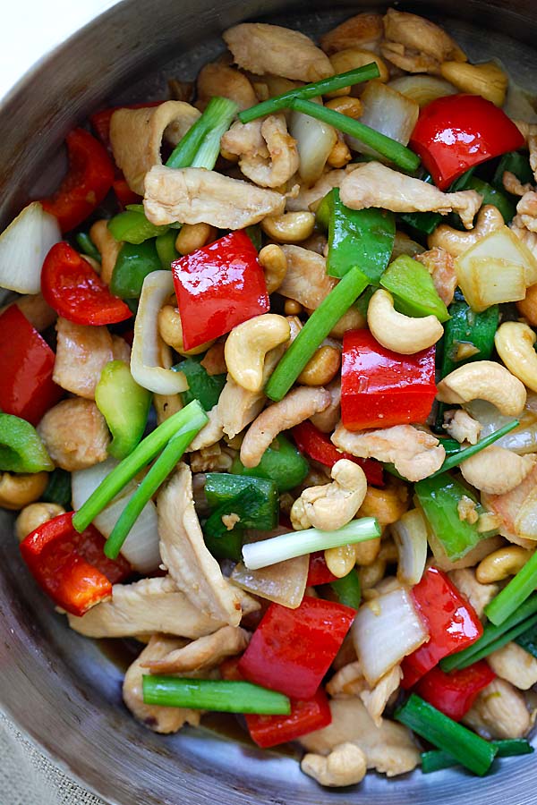 Top down view of tasty Thai stir-fry cashew chicken in brown sauce cooked with bell peppers, onions and scallions.