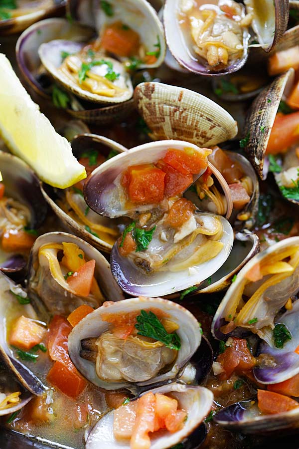 Healthy homemade Italian skillet sauteed clams with garlic, tomatoes, white wine and parsley ready to serve.