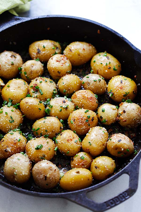 Easy homemade roasted baby potatoes with garlic, chives, butter and Parmesan cheese in a skillet.