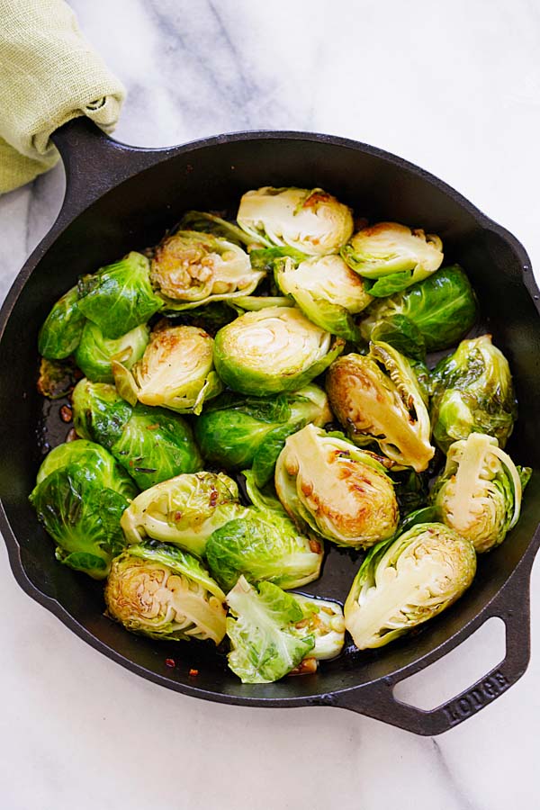 Quick and healthy sauteed Brussels Sprouts with honey and balsamic vinegar in a skillet.