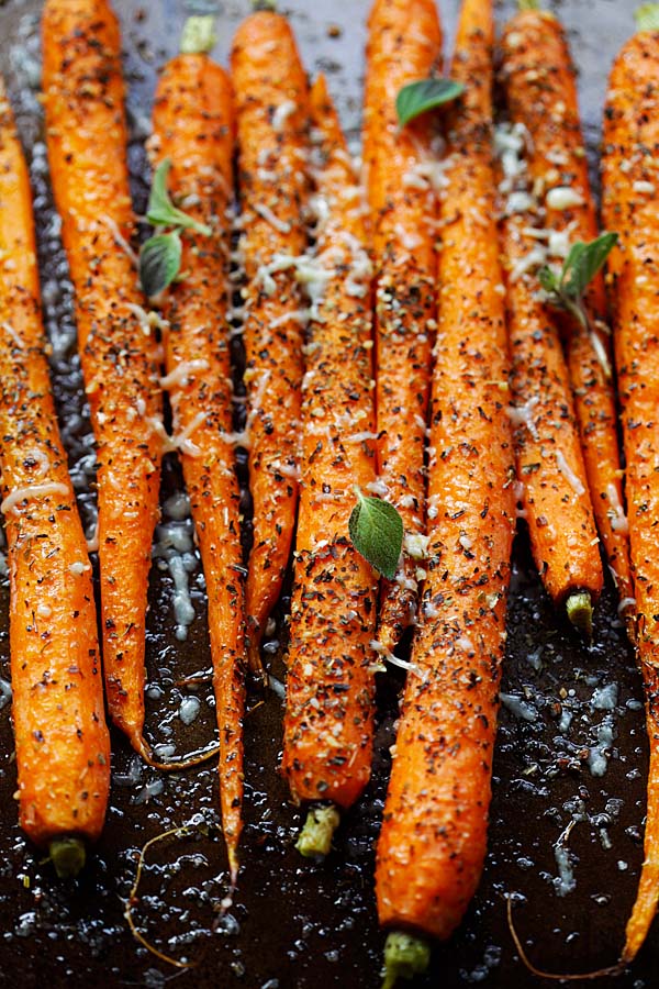 Healthy homemade roasted carrots topped with Italian seasonings, fresh herbs and Parmesan cheese.