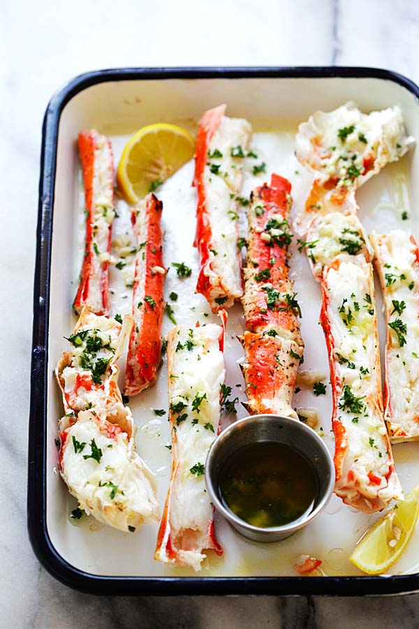 Crab legs with garlic lemon butter on a tray.