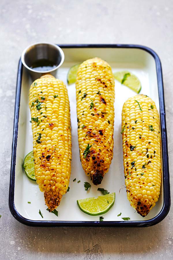 Easy and quick honey butter cilantro lime grilled corn in a baking tray.
