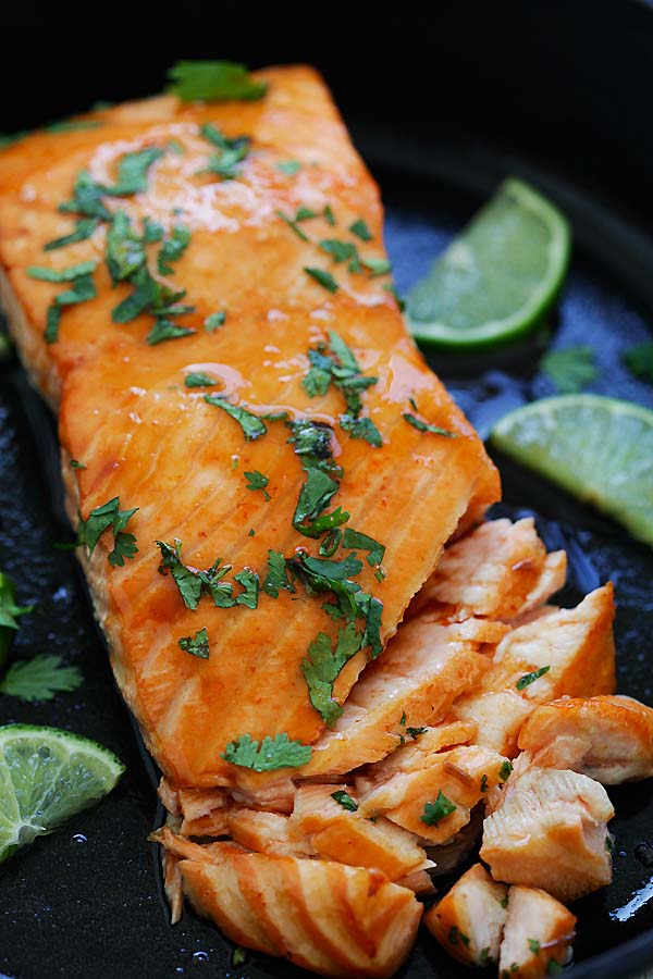Baked flaky salmon with delicious Sriracha and lime juice marinade, in a skillet.