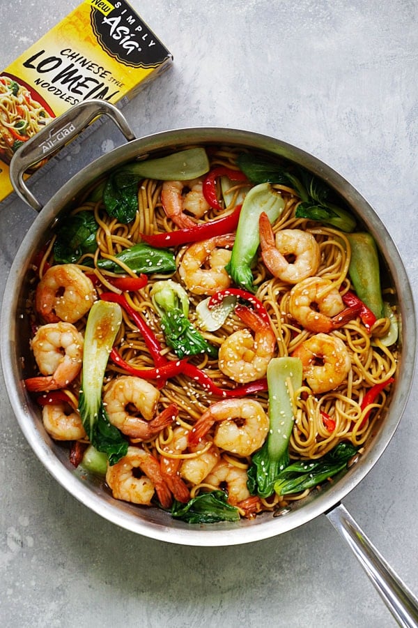 Perfectly cooked delicious shrimp lo mein in a pot covered in bok choy and red peppers.
