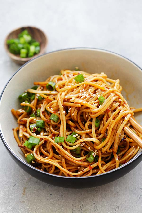 Easy and delicious spicy Chinese Sichuan cold dry noodles topped with sesame seeds and chopped scallions.