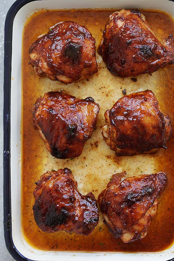 Baked honey barbecue chicken thighs marinated with smoky honey barbecue sauce in a baking tray.