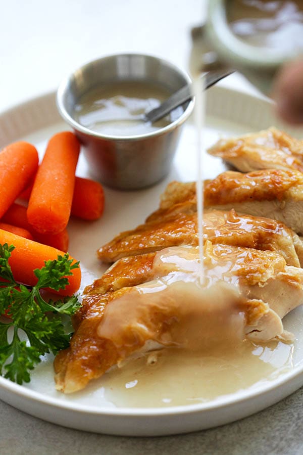 Easy Gravy dripping onto roasted chicken in a plate.