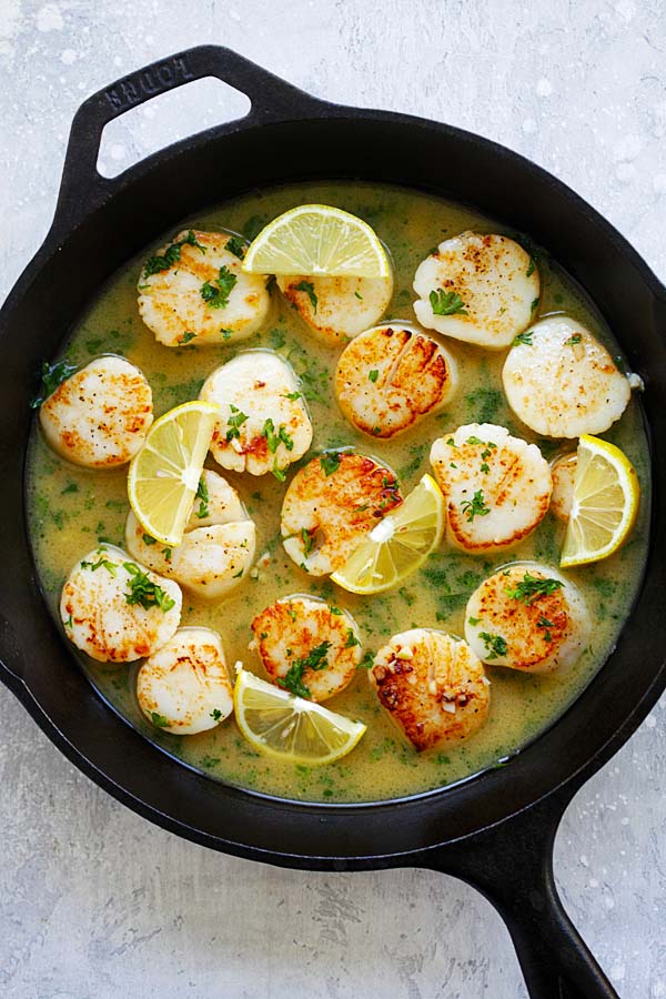 Garlic butter scallops with lemon sauce in a skillet.