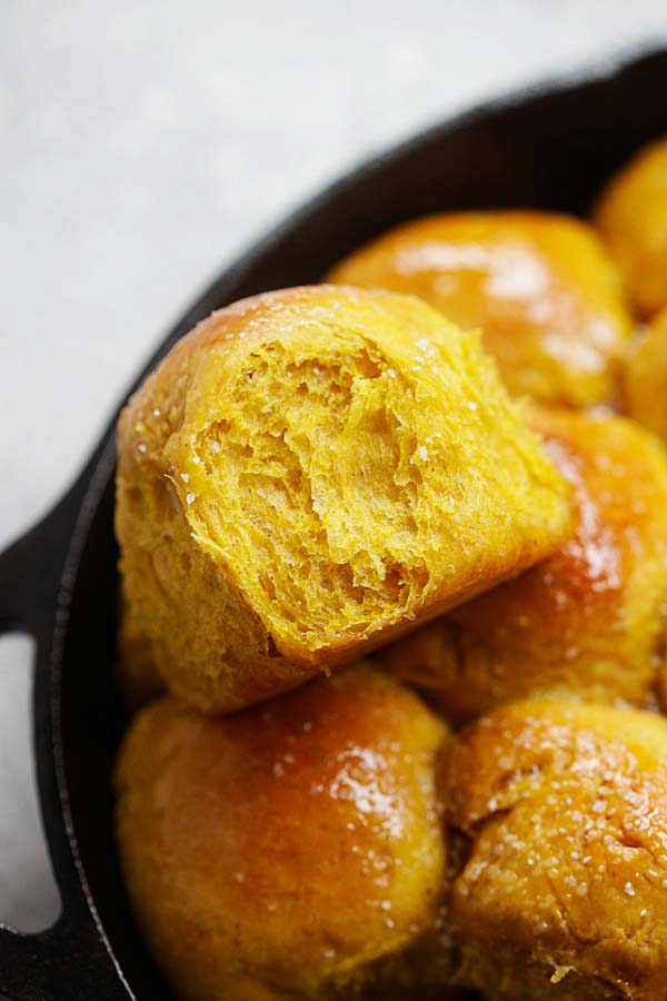 Fluffy and soft homemade pumpkin dinner rolls close up in a skillet.