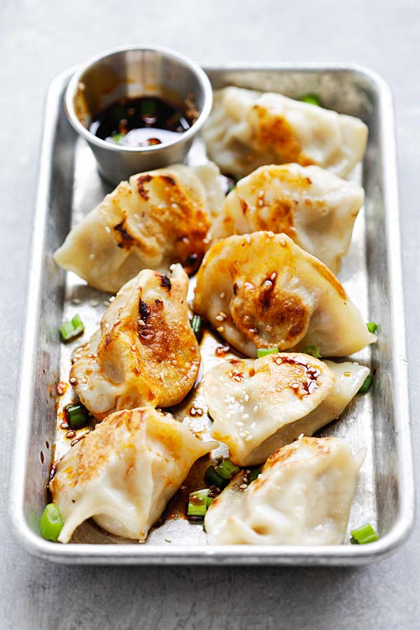 Homemade chicken dumplings with a side of dumpling sauce.