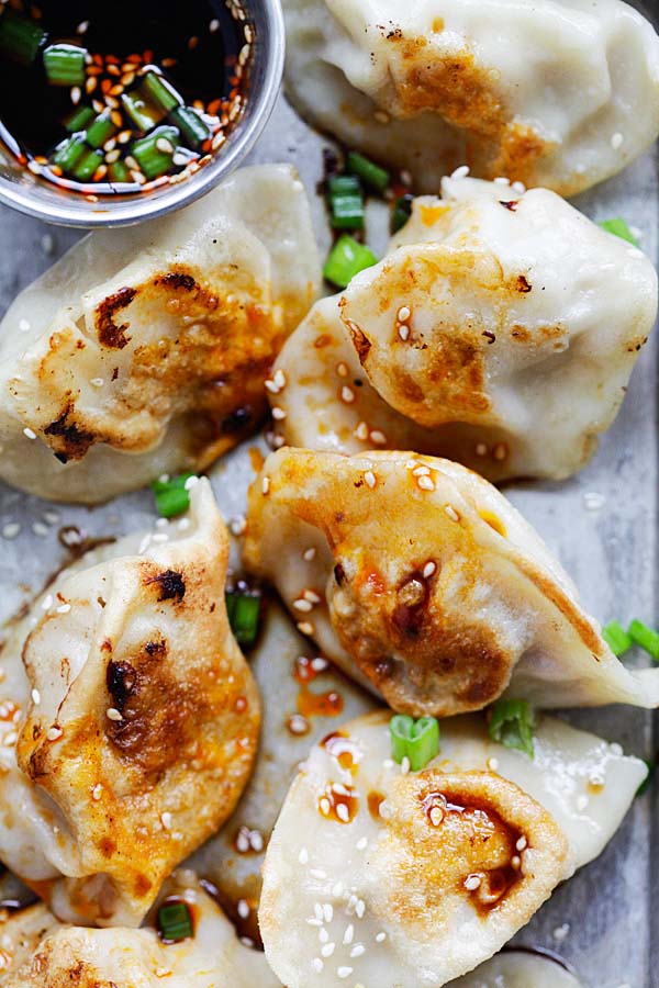 Pan-fried chicken dumplings with dipping sauce.