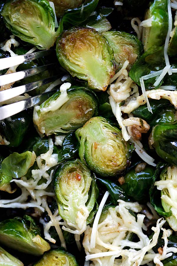 Roasted brussels sprouts with garlic and Parmesan cheese with a fork.