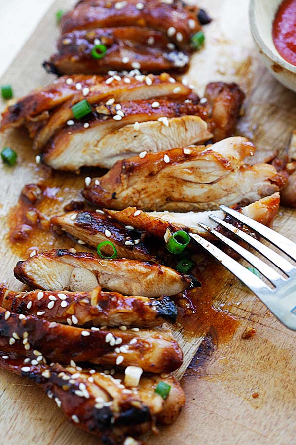 oven baked Garlic Sriracha Chicken garnished with chopped scallion.