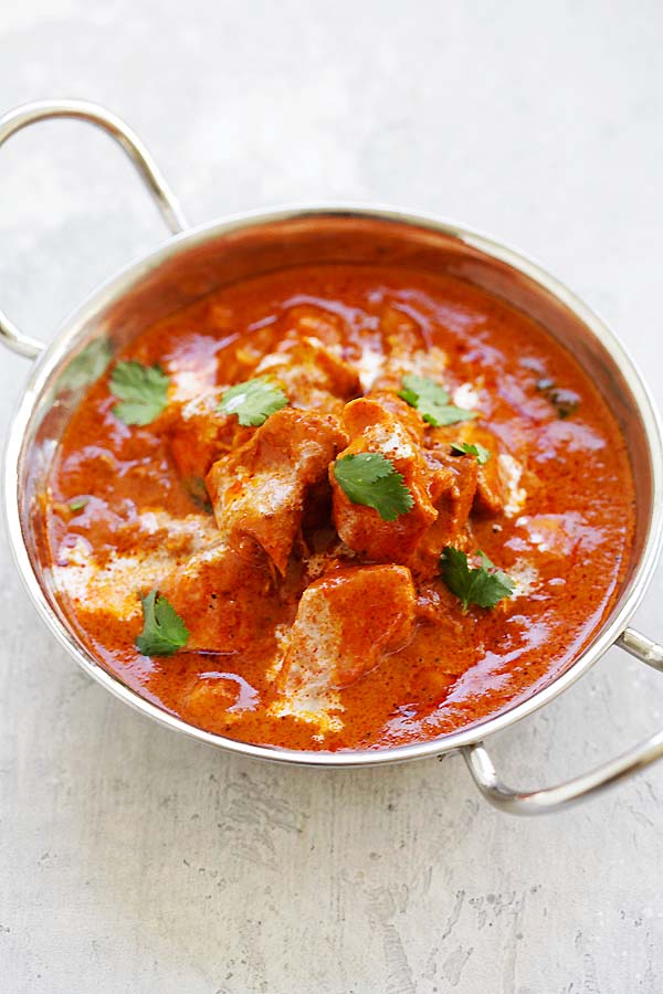 Indian butter chicken instant pot  in a silver serving ware, served with naan and basmati rice.