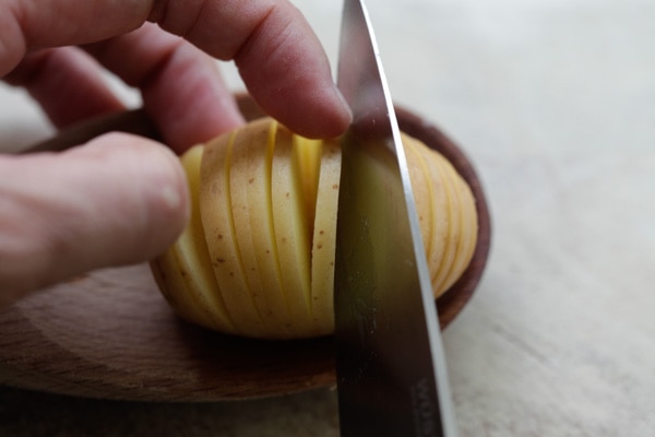 Cutting Hasselback potatoes with a knife.