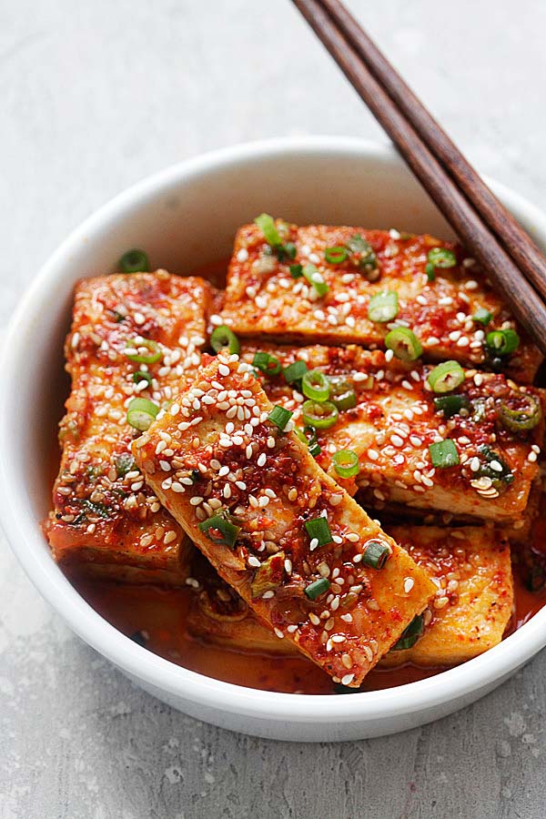 Homemade healthy and delicious spicy Korean Tofu Banchan in a bowl with a pair of wooden chopsticks.