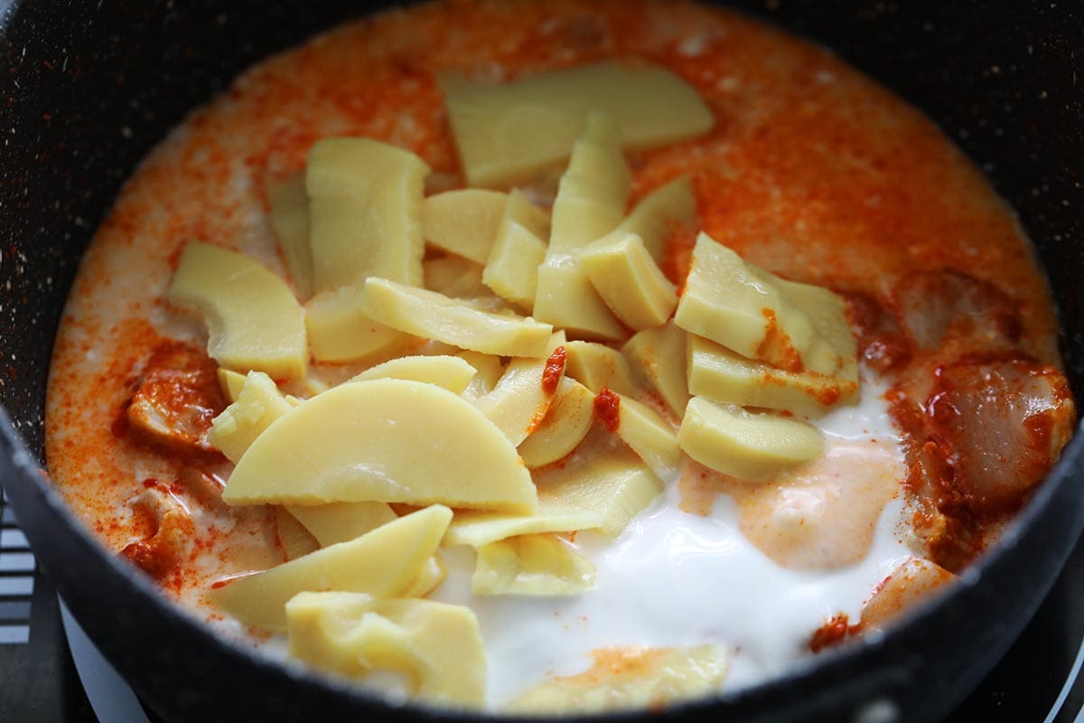 Adding bamboo shoots to red curry recipe.