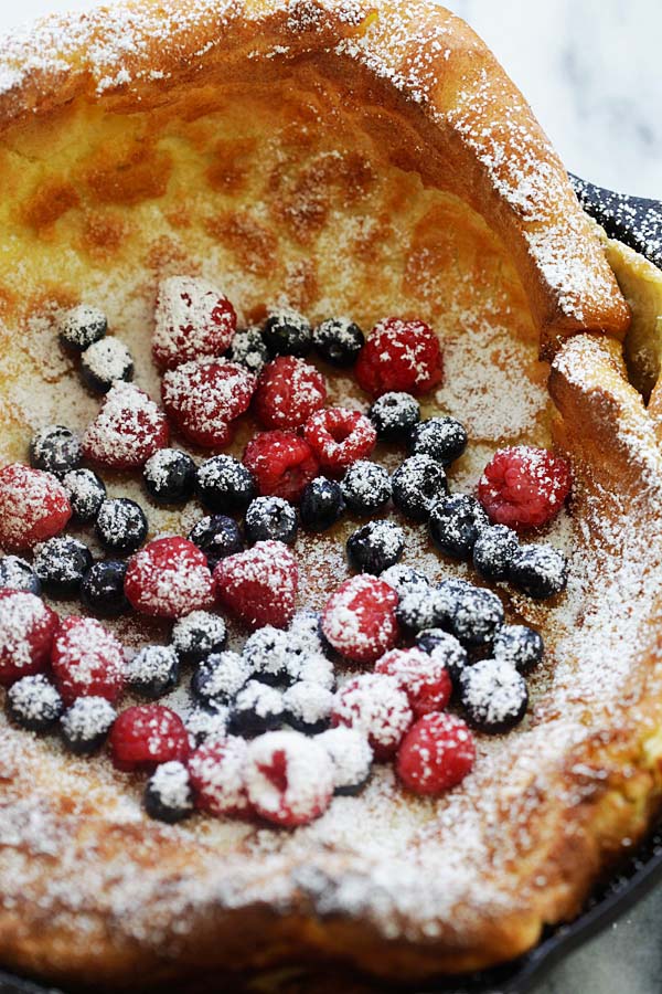 Homemade Dutch baby pancake topped with berries and powdered sugar.