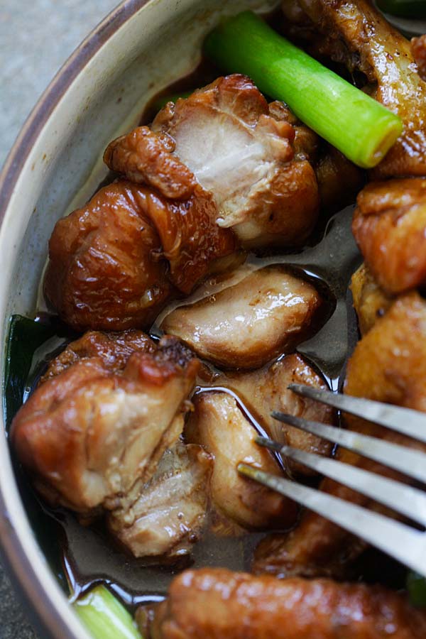 Juicy and tender Asian Ginger Soy Chicken in a serving dish with a fork.
