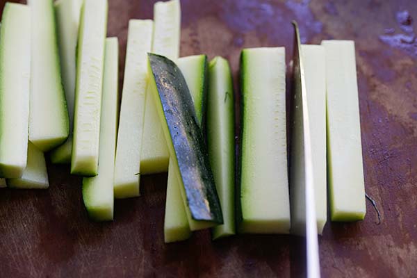 Cutting a zucchini into zucchini fries. 