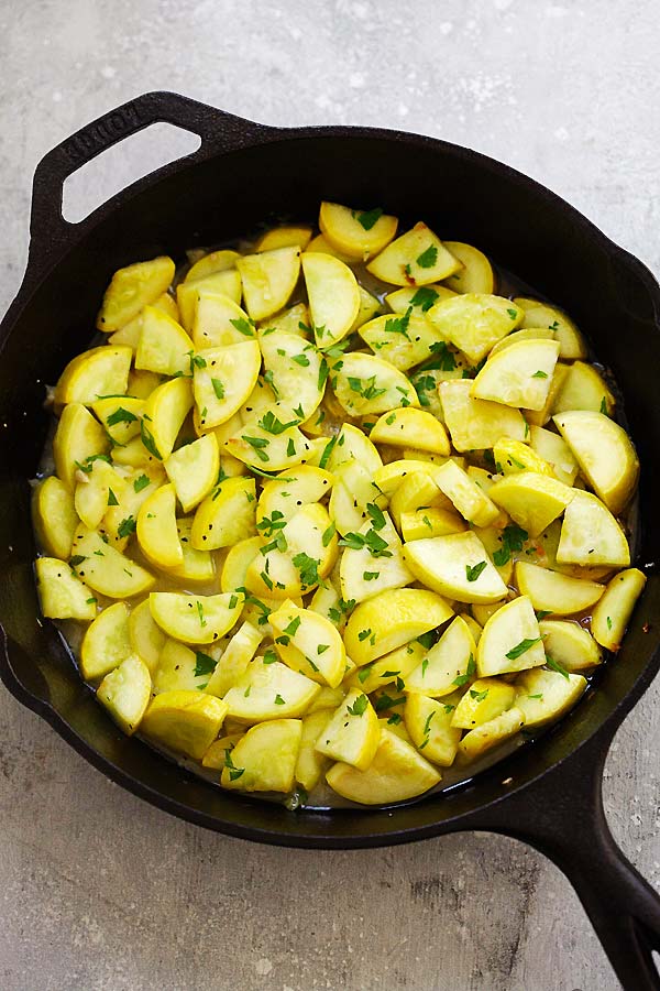 Sauteed Yellow Squash with garlic, butter and lemon in a pan.