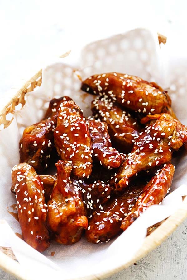 =Crispy oven-baked chicken wings with homemade sweet and sour sauce topped with sesame seeds.