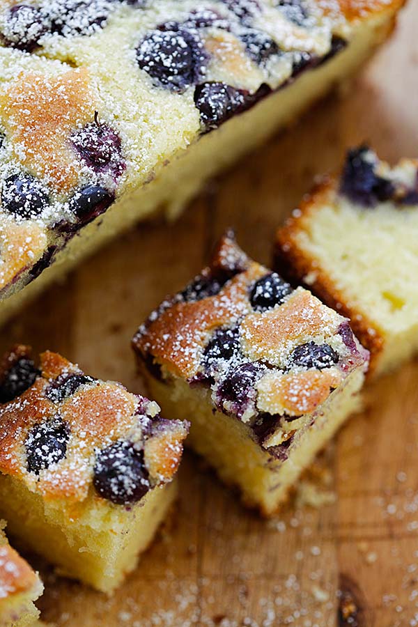 Butter cake with blueberries on top, cut into bite-sized pieces.