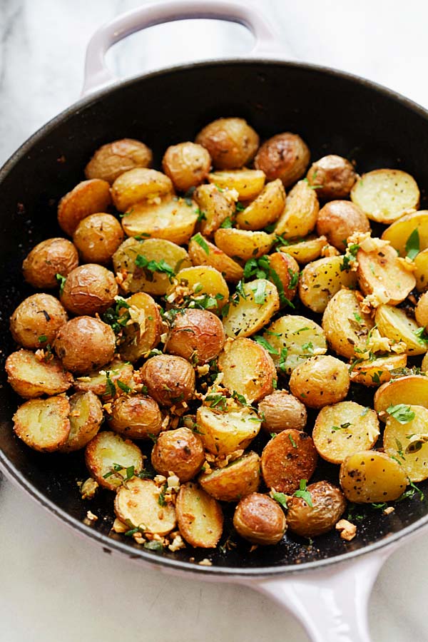 Crispy Roasted Potatoes with garlic herb infused oil in a skillet.