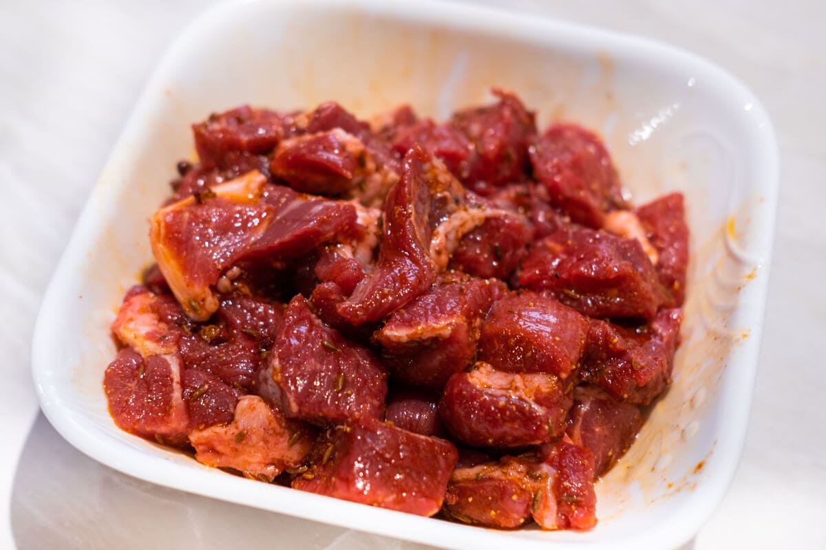 Marinated lamb cubes in a bowl.