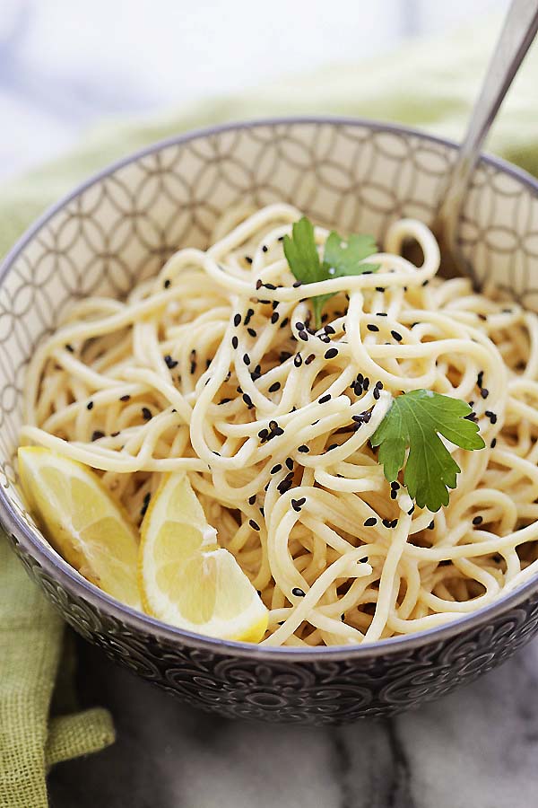 Easy and quick Asian sesame noodles topped with black sesame, served in a bowl.