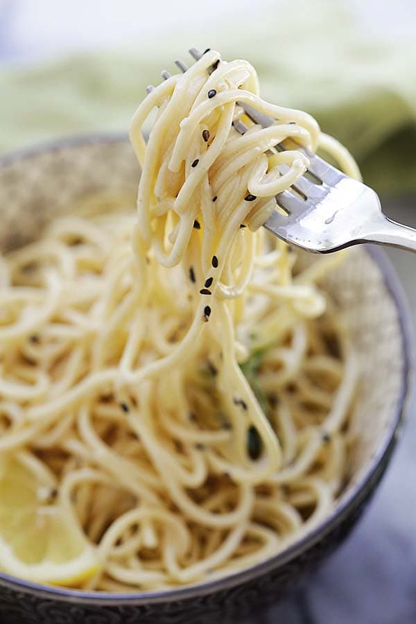 Close up of sesame noodles twirled on a fork.