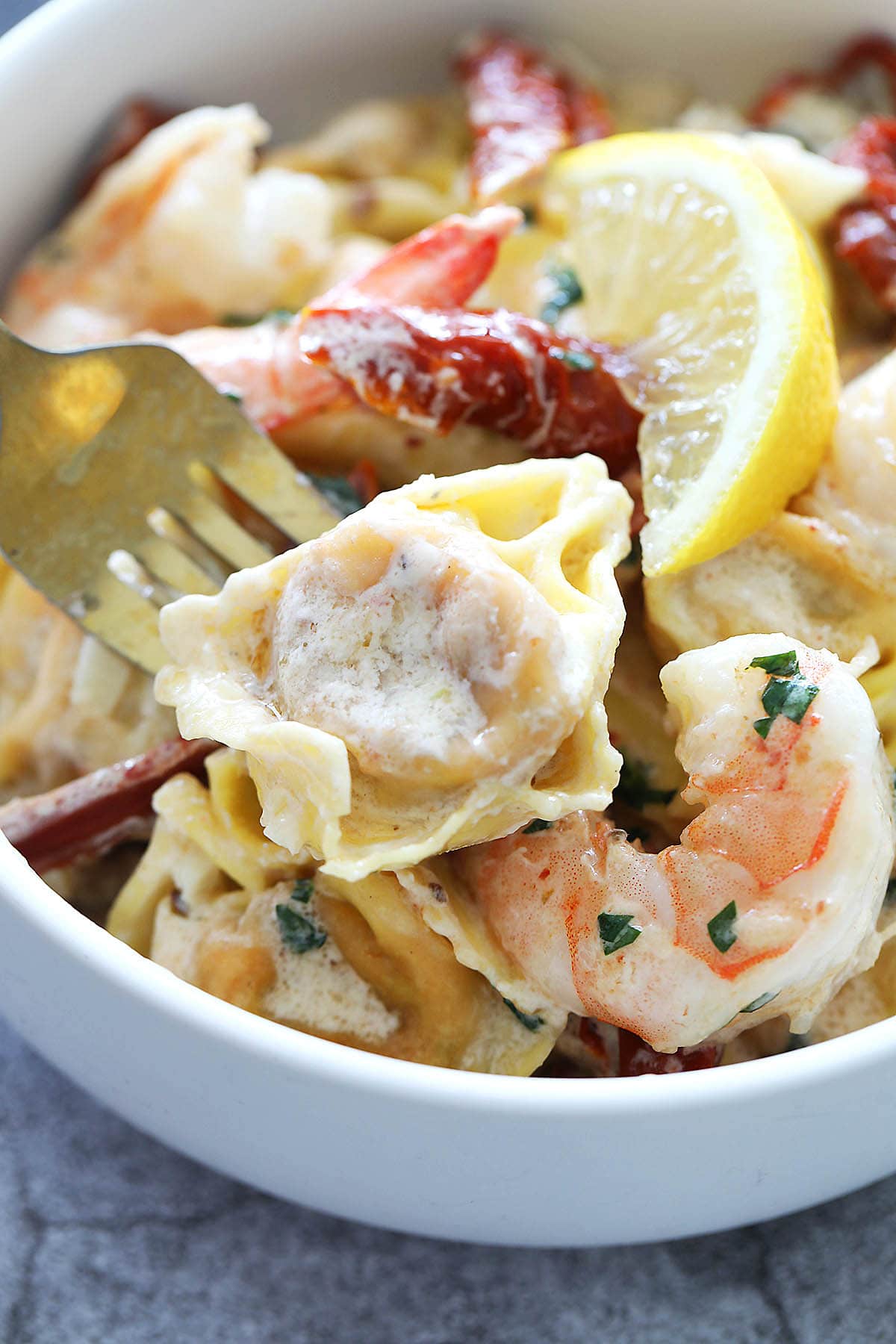 A piece of tortellini pasta with a fork. 