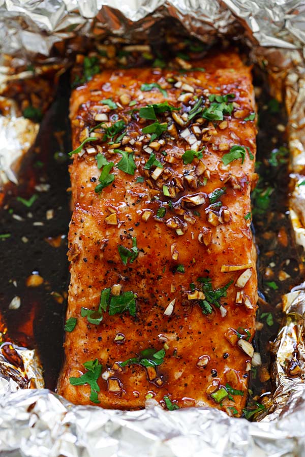 Juicy and flaky foil baked salmon recipe with a mouthwatering garlic sriracha marinade.